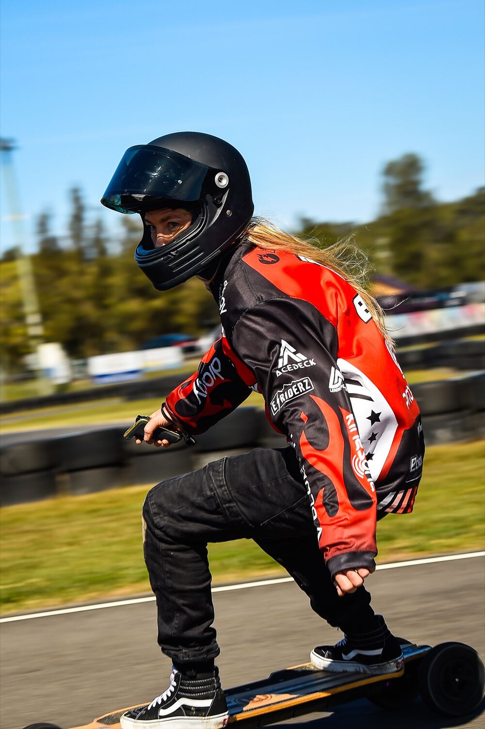 An ESRA eSkate racer in red, carving through a corner